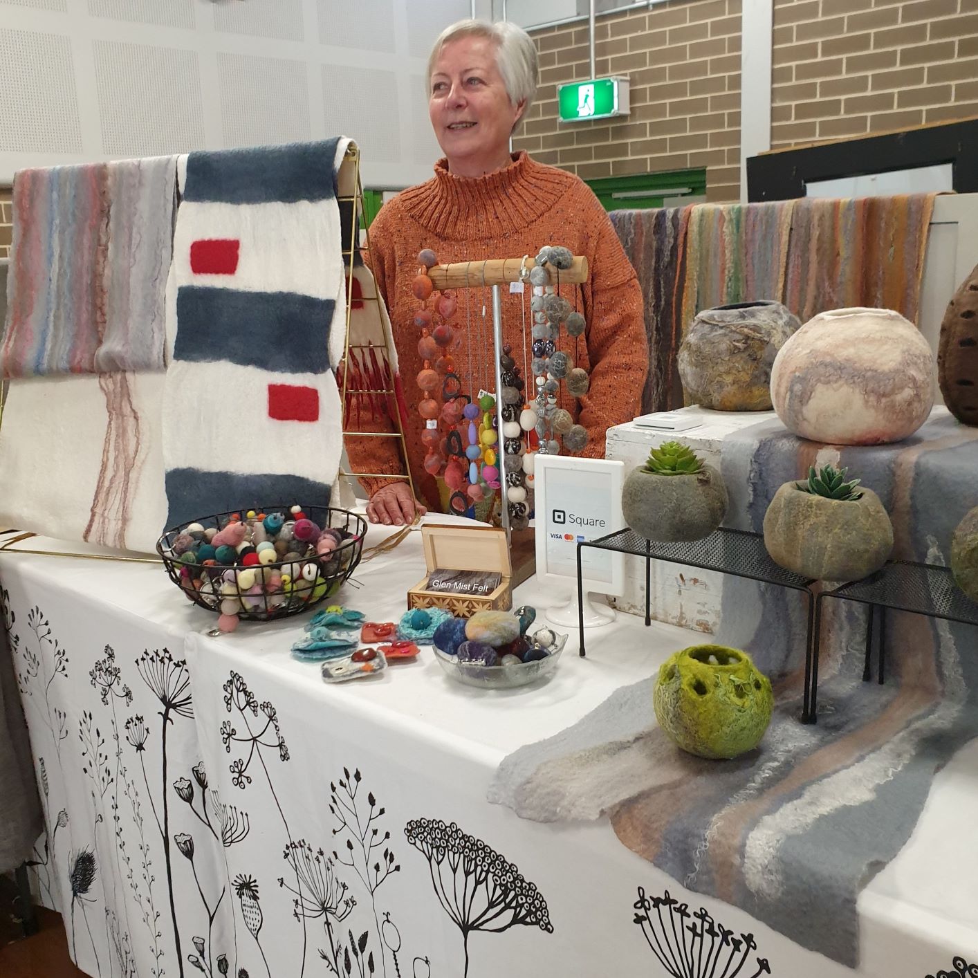 photograph of a woman selling felt products