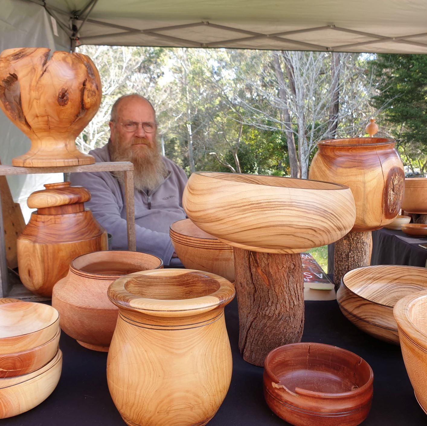 Photo of a stall with a man selling woodturned products